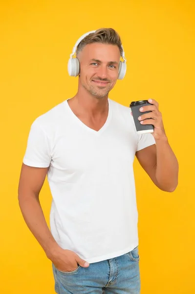Καυκάσιος μεσήλικας πίνει καφέ ντελίβερι ακούγοντας μουσική σε casual στυλ μόδας κίτρινο φόντο, πίνοντας — Φωτογραφία Αρχείου
