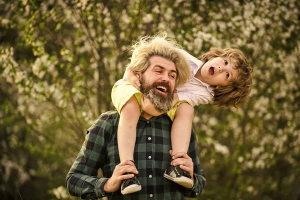 Helg med familjen. Glad familjedag. Våren kommer. Ha det så kul. Kärlekskoncept. Pappa leker med sitt barn i parken. Snygg pappa med sin söta son. njuta av blomning och natur tillsammans — Stockfoto