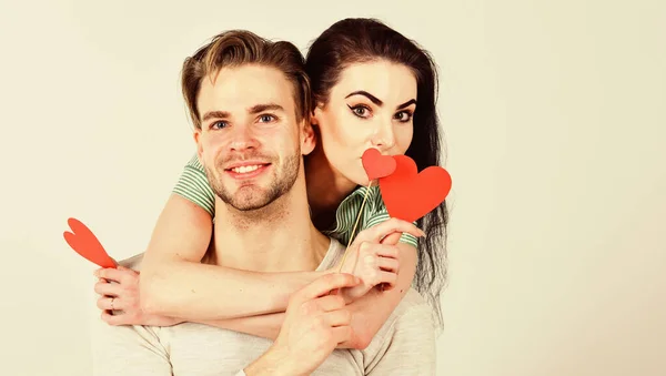 Man and pretty girl in love. Valentines day and love. Romantic ideas celebrate valentines day. Valentines day concept. Man and woman couple in love hug and hold red heart valentines cards close up — Stock Photo, Image