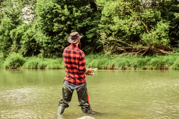 Casting off. serious man in cowboy hat. western portrait. Vintage style  man. Wild West retro cowboy. fly fishing. man checkered shirt on ranch.  fisher hold fish net. hobby. fisherman with fishing rod Stock Photo - Alamy