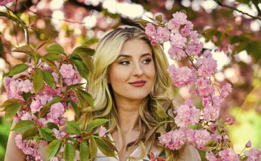 Mutlu bahar günleri. Uyum ve kadın enerjisi. Bahar sembolü Kız bahçedeki sakuranın tadını çıkarıyor. Kiraz ağacı. İyi titreşimler. Çiçek aroması. Bahar çiçeği açan ağaç. Çiçeklerin kadınları neden her zaman mutlu ettiğini.