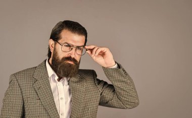 Resmi ofis hayatı. Ciddi sakallı adam. Pahalı takım elbiseli yakışıklı ve başarılı bir adam. O, beyaz gömlek ve gözlük takıyor. Takım elbiseli başarılı bir adam. İş adamı takım elbise giyer