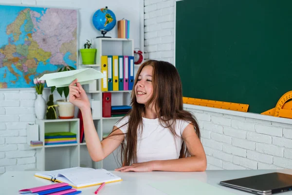 Laten we vliegen. ontwikkeling van kinderen. kennis verwerven door middel van studie. Een kind in de klas met schoolbord. een papieren vliegtuig vasthouden. terug naar school. formeel onderwijs in het moderne leven. Thuisonderwijs — Stockfoto