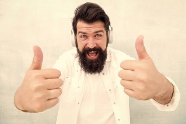 İnsan Duyguları kavramı. Kulaklıklı Müzik Dinleyen Adam. Hippi kulaklıkla harika bir ses şarkısının keyfini çıkarır. Beyaz adam kablosuz bluetooth kulaklık kullanıyor. Mutlu adam başarı için parmağını kaldırdı.