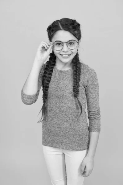 Αξιολάτρευτο φυτό. Σχολική ιδέα. Έξυπνο κορίτσι με κακή όραση. 'σε με να δω. Διαβάζει καλύτερα με γυαλιά. Γυαλιά για την υγεία των ματιών. Έξυπνο κορίτσι. Κορίτσι μαθητής σχολείο φορούν γυαλιά ηλίου κίτρινο φόντο — Φωτογραφία Αρχείου
