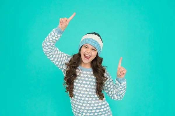 뜨개 질 스웨터를 입고 모자를 쓴 행복 한 10 대 소녀가 손가락을 치켜올리며 창조적 인 아이디어를 즐기고 있습니다. — 스톡 사진
