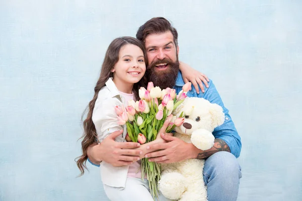 Padre e hija abrazo con primavera tulipán ramo de flores y peluche oso juguete, día de las mujeres — Foto de Stock