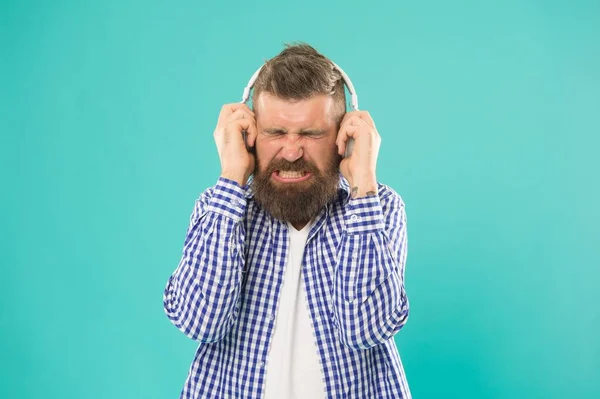 Baja el sonido. desdichado hipster escuchar ebook. hombre barbudo con sonido fuerte en auriculares. — Foto de Stock