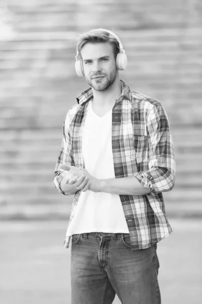 Homem moderno ouvindo música fones de ouvido sem fio, caminho para o conceito de universidade — Fotografia de Stock