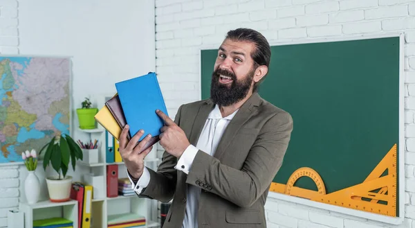 Щасливий вчитель з робочою книгою та книжками, готовими до уроку, школи — стокове фото