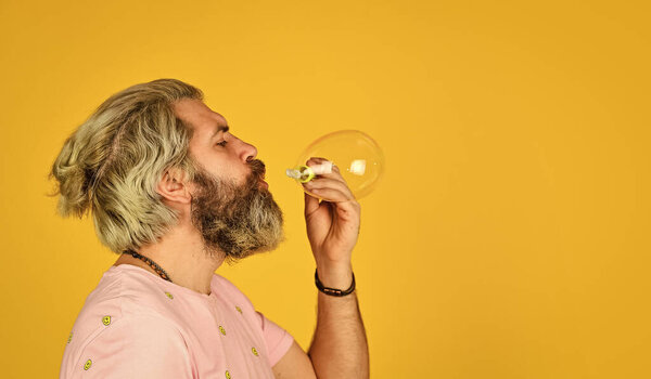 Positive. Carefree man soap bubbles. Summer vacation. Infantility concept. Happy playful bearded hipster and soap bubbles. Happiness and joy. Good vibes. Blow inflate bubbles. Forever young guy