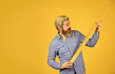 Santimetre boyunda. Okul eğitimi. Bedava eğitim. Geometri öğretiyorum. Uzun ya da kısa. Sakallı adam cetvel kullanıyor. Eğitim konsepti. Sıkı çalış. Okul dersleri. Ölçüm aracı. Kök öğretmeni