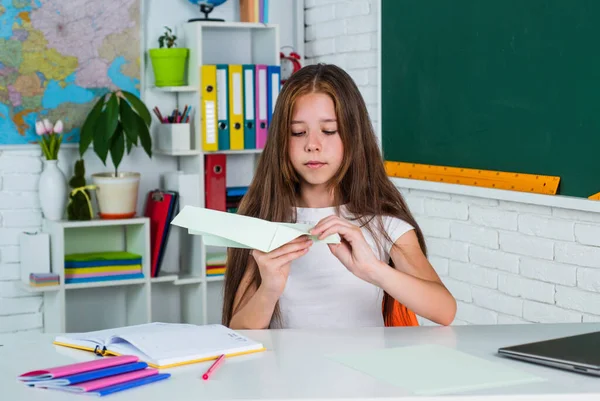 Cute teen kid near chalkboard with paper plane, back to school — Stock Photo, Image