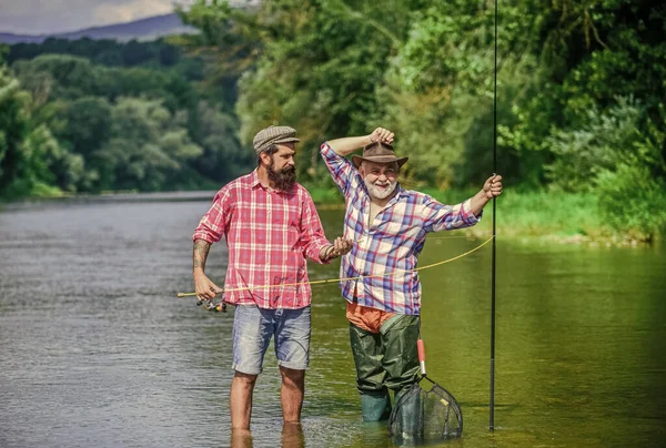 Mestre Baiter. Pescador com cana de pesca. Atividade e hobby. Pesca lago de água doce lagoa rio. Homens barbudos a pescar peixe. Homem maduro com amigo pesca. Férias. Pessoas alegres felizes — Fotografia de Stock