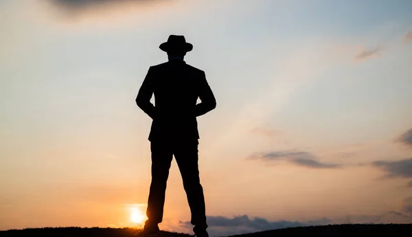 Silueta del hombre en sombrero de pie en el cielo del amanecer, la soledad — Foto de Stock