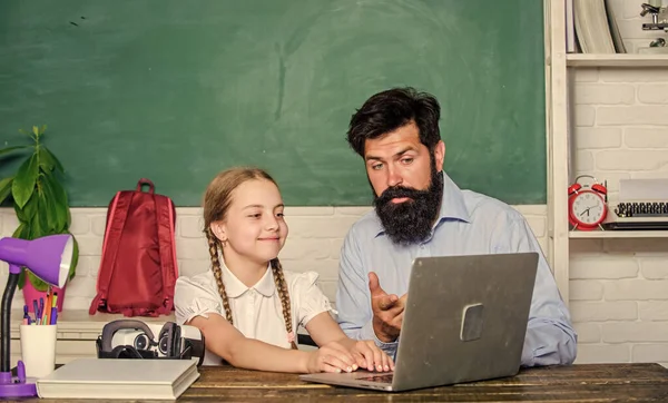 Study modern technologies. School teacher and schoolgirl with laptop. Man bearded pedagogue teaching informatics. Homeschooling with father. Find buddy to help you study. Private lesson. Study online