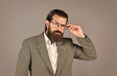 Kendine güvenen ve şık. Erkek ceketi dolabı. Modaya uygun bir adam gözlük takıyor. Resmi manken. Gri arka planda yakışıklı bir adam. Ciddi sakallı iş adamı. Modern görünümlü şık olgun bir adam.