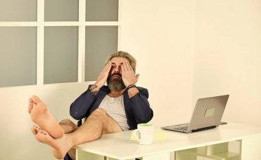 Lüks ve başarı. Bedava boş zaman. Modern iş hayatı. Çıplak ayaklı adam evde dizüstü bilgisayardan film izliyor. Siber pazartesi indirimi. Alternatif ofis çalışanı. ev internet kullanarak çalışıyor