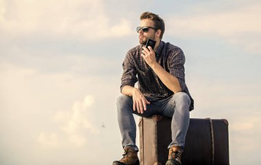 Ulaşım tesisleri. Bagaj konsepti. Yakışıklı gezgin. Klasik valizli bir adam. Taksi çağırıyorum. Seyahat acentesi. Bagajla seyahat et. Gezgin blogcu. İnsan yolculuktan önce bavula oturur.