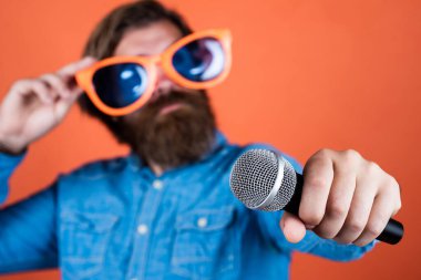 Kafkas hippinin elindeki mikrofon sakallı ve şık saçlı sanat gözlüklü, seçici odaklı, cihaz