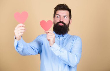 Her gün sevgililer günü. Kalp şeklinde kartları olan seksi bir sevgililer günü erkeği. Sevgililer günün kutlu olsun. Romantik aşk kutlaması. Kırmızı kalp tutan sakallı adam. Küçük kalpli hippi.