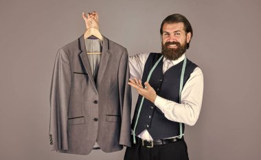 Individual measures the hand of man. Man is ordering business suit posing indoors. Tailor measures man. stylish business man at workspace. Fashion design studio. Male fashion designer clipart