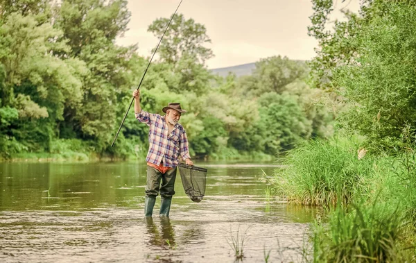 Pessoas fixes pescam. Fim de semana. Grande jogo de pesca. homem maduro voar pesca. Homem a pescar peixe. pescador barbudo aposentado. Isca de truta. pescador com vara de pesca. atividade desportiva hobby. pothunter — Fotografia de Stock