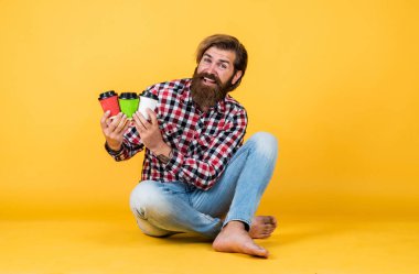 Mutlu, sakallı, sakalsız, şık saçlı, sıradan kıyafetler giyen, kahve içen, barista