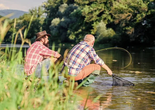 Padre in pensione e figlio barbuto maturo. pesca d'altura. rilassarsi sulla natura. Due amici maschi che pescano insieme. amicizia dei pescatori. hobby di pesce di mosca di uomini. pesca a riposo. tutto su angolo retto — Foto Stock