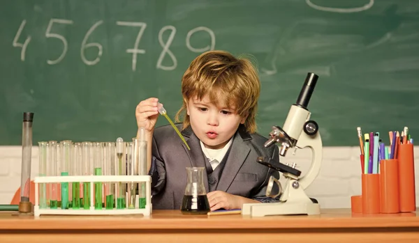 Technologia i koncepcja nauki. Chłopiec koło mikroskopu i probówki w klasie szkolnej. Dzieciak studiuje biologię i chemię w szkole. Edukacja szkolna. Zbadaj molekuły biologiczne. Maluch geniusz dziecko — Zdjęcie stockowe