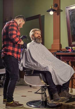 Yeni tarzını seviyor. Sakal ve bıyık. Berber dükkanında profesyonel kuaför. Şık erkek sakalı portresi. Tıraş. Berber dükkanındaki kuaför. Kuaförde hippi tıraşlı bir adam.