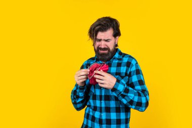 Kafkasyalı yetişkin sakallı adam sarı arka planda boş cüzdan taşıyor. Yoksulluk krizi konsepti.