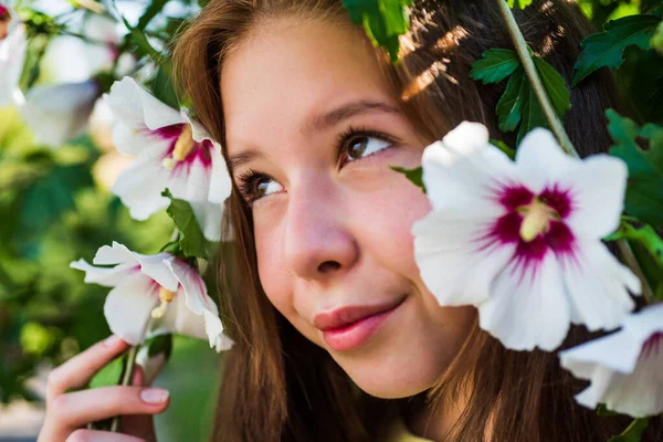 Весела дівчинка серед квітучих гібіскусів квітка навесні, краса — стокове фото