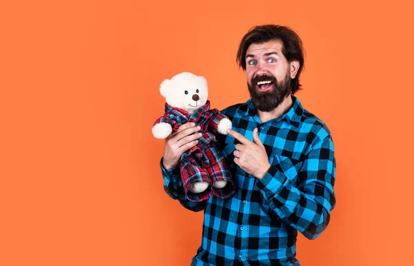 Жорстокий бородатий чоловік зі стильним виглядом грає з ведмедем, плюшевим ведмедем — стокове фото