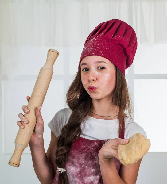 Adolescent fille dans cuisinier uniforme préparer la nourriture dans la cuisine, culinaire — Photo