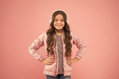 Eğlence ve eğlence. Modern yaşam tarzı. Müzik neşe verir. Mutlu çocuk pembe arka plan müziği dinle. Küçük kız müzik çalarken kulaklık takıyor. Çocuklar için yeni teknoloji