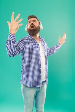 Sıradan tişörtlü sakallı adam şarkısını mavi arka plandaki yığınla şarkıyı dinle, müzik.