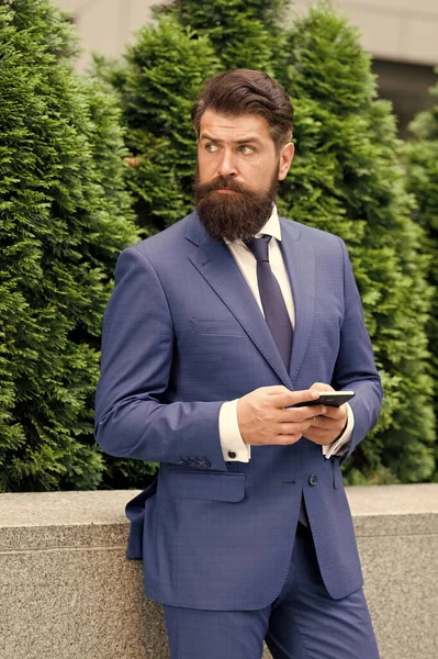 Always available. your future employer. handsome manager use smartphone. man in formal outfit outside. realtor button jacket. modern life concept. portrait of confidence. successful insurance agent