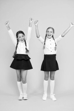 Başarının tadını çıkarıyor. Mutlu çocuklar sarı arka planda başarıyı kutluyor. Küçük liseli kızlar başarı için heyecanlanıyorlar. Sevimli küçük çocuklar başarı için kazanan jestler yapıyor.