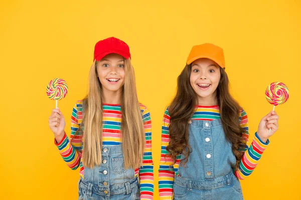 Druk positiviteit uit. Lachende zusjes lolly snoep. Kinderen hebben feestplezier. schoolvrienden vieren vakantie. snoepwinkel concept. Een mooi leven. Gelukkige jeugd. positief en vriendelijk. Gelukkige kinderdag — Stockfoto