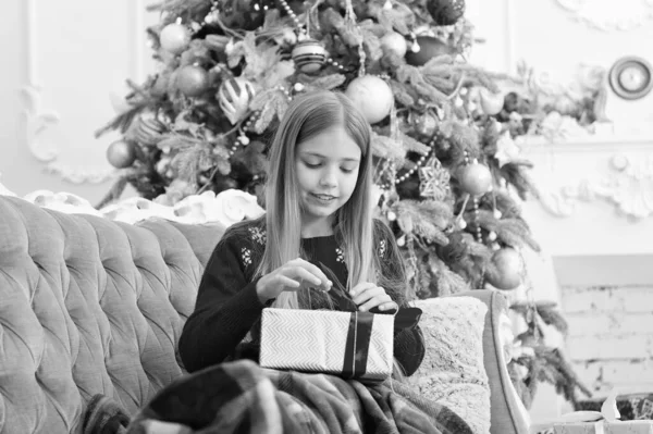 Amarrar um laço de fita. O dia do boxe é o dia após o Natal. Menina com caixa de presente. A criança feliz celebra o Natal e o Ano Novo. Menina criança se preparar para as férias do dia de boxe. Feliz Ano Novo — Fotografia de Stock