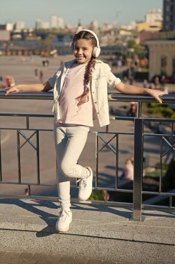 Şehirler ve müzeler arasında heyecanlı seyahatler. Şehir rehberi ve ses turu. Küçük turist kız ses kılavuzu mobil uygulaması kullanıyor. Ses turu kulaklıkları. Serbest seyahat biçimi