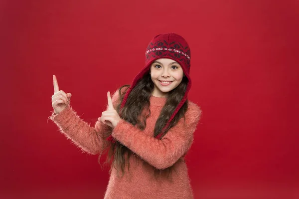 Guardi qui. Il concetto di presentazione. Vestito invernale. Il bambino indossa un cappello a maglia. Stai al caldo. Accessorio moda bambina inverno. Piccolo bambino indossare cappello sfondo bordeaux. Carino modello godere di stile invernale — Foto Stock