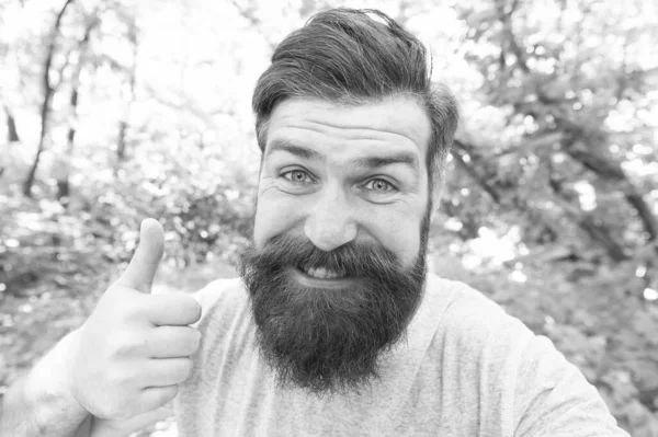 Donner un pouce à son coiffeur. Joyeux geste de coiffeur sur un paysage naturel. Homme barbu avec barbe en forme et cheveux de moustache souriant avant ou après la visite coiffeur. Un salon de coiffure réservé aux hommes — Photo