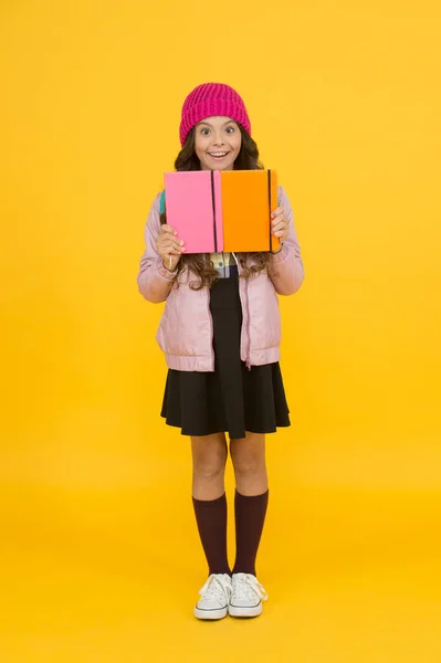 Шкільна дівчинка. Щаслива дівчина повертається до школи восени. Маленька дівчинка позичає книжки в бібліотеку. Маленька дівчинка посміхається у формальній шкільній формі. Освіта та навчання. Знання та інформація — стокове фото