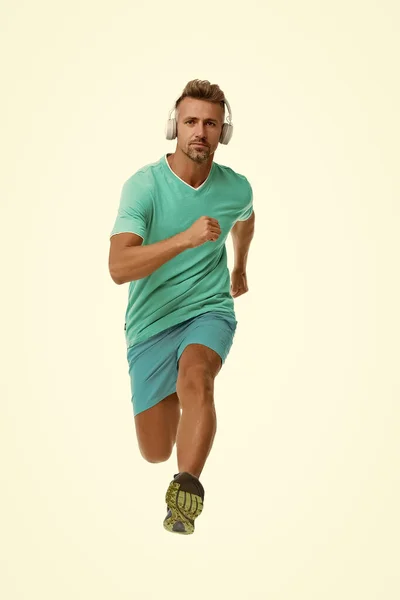 Motivational song. Man sportsman running with headphones. Runner handsome strong guy in motion isolated on white. Music fuel for workout training. Run faster. Running sport. Keep running every day — Stock Photo, Image