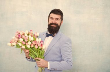 Çiçek teslimatı. Centilmen romantik randevu. Doğum günü tebrikleri. Kız arkadaş için en iyi çiçekler. Çiçekler onun için. Sakallı adam papyonlu lale buketi tutuyor. Beyefendi ona romantik bir sürpriz hazırlıyor.