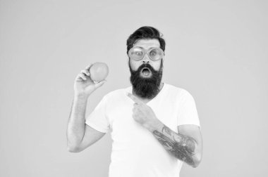 Sarı arka planda turuncu güneş gözlüklü sakallı hippi. Tazeleme kaynağı. Yaz beslenmesi. Yaz havasında sakallı hippi. Neşeli adam olgun turuncu turunçgil meyvesi tutuyor. Yaz tatili