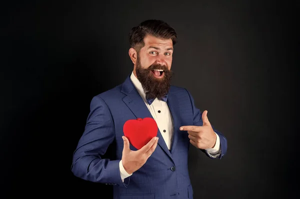 Ünnepeld a szerelmet. Bízz bennem. Boldog Valentin napot! Tuxedo férfi tartja piros szív. Szerelmi koncepció. Szenvedélyes felnőtt szerető hipszter formális öltönyben. Üzletember csokornyakkendővel. Romantikus üdvözlés. Szerelembe esni. — Stock Fotó