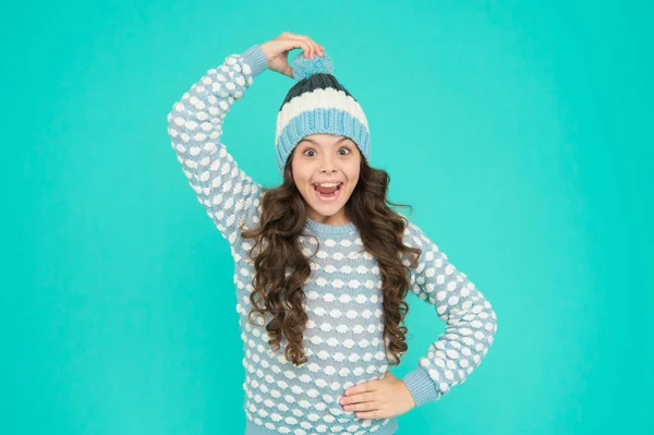 Menina criança alegre desfrutar do tempo de inverno em chapéu de malha e suéter no fundo azul, felicidade — Fotografia de Stock